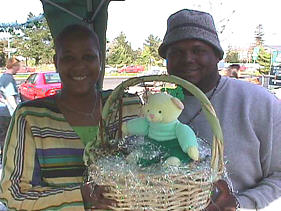 Tina and Aaron hold an unwrapped custom Saint Patty's Day Gift Basket